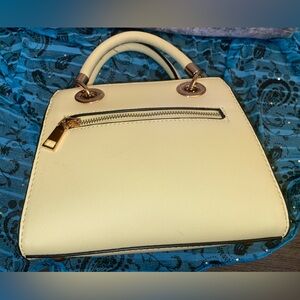 Light yellow handle bag with shoulder strap.